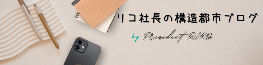 「リコ社長の構造都市ブログ」のロゴバナー。ノートとペン、スマートフォンが並ぶ机上にブログタイトルが記されている。