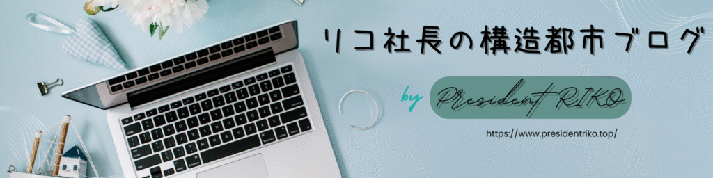 ノートパソコンと文具、白い花が置かれた淡いブルーのデスク背景に、「リコ社長の構造都市ブログ by President RIKO」とURLが記されたヘッダーバナー。